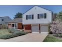 Inviting home with a lush green lawn, brick details, and a two-car garage at 5759 E Geddes Cir, Centennial, CO 80112