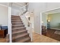 Spacious foyer featuring staircase, wood floors, and views into adjacent living spaces at 762 Hughes Ln, Highlands Ranch, CO 80126