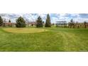 Scenic golf course with manicured green, mature trees and community buildings in the background under a bright blue sky at 750 S Clinton St # 6B, Denver, CO 80247