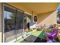 Outdoor patio with sliding glass door, unique furniture and decor, and faux grass surface under natural sunlight at 750 S Clinton St # 6B, Denver, CO 80247