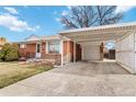 Exterior of brick home with a covered carport and extra storage at 6900 Avrum Dr, Denver, CO 80221