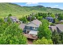 Back of the home featuring a spacious wooden deck perfect for outdoor entertaining and a green, lush backdrop at 18967 W 54Th Ln, Golden, CO 80403