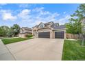 Charming two-story home with a three-car garage, and lush green lawn at 9548 La Quinta Dr, Lone Tree, CO 80124