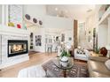 Open-concept living room with fireplace, hardwood floors, and views into the kitchen and staircase at 6500 W Mansfield Ave # 39, Denver, CO 80235