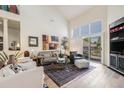 Bright living room featuring hardwood floors, high ceilings, and large windows with sliding doors to the backyard at 6500 W Mansfield Ave # 39, Denver, CO 80235