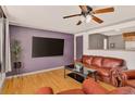Open-concept living room with a ceiling fan, a large TV, and seamless kitchen access at 609 S Quentin St, Aurora, CO 80012
