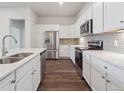 A kitchen featuring stainless steel appliances, sleek white cabinets, and a stylish gray backsplash at 485 Interlocken Blvd # 103, Broomfield, CO 80021