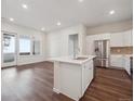 Modern kitchen with stainless steel appliances, white cabinets, and island with sink at 485 Interlocken Blvd # 103, Broomfield, CO 80021