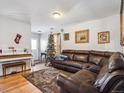 Living room with leather couch, Christmas tree, and piano at 4982 W Kentucky Ave, Denver, CO 80219