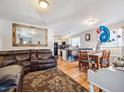 Open living room with leather couch and dining area at 4982 W Kentucky Ave, Denver, CO 80219