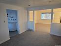 Bright living room with built-in shelving and view to kitchen at 360 S Bryant St, Denver, CO 80219