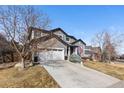 Charming two-story home with a well-manicured lawn and attached two-car garage at 9925 Keenan St, Highlands Ranch, CO 80130