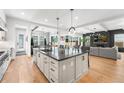Open-concept kitchen with an oversized island, modern pendant lighting, and stainless steel appliances at 2255 S Monroe St, Denver, CO 80210