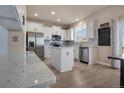 Well-lit kitchen with white cabinets, stainless steel appliances and a center island with granite countertops at 24317 E Powers Ave, Aurora, CO 80016