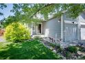 Charming home exterior featuring a well-manicured lawn and beautiful flower beds along the front walkway at 7871 Ogden Ct, Denver, CO 80229