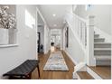 Bright entryway with hardwood floors, bench, and staircase leading upstairs at 1460 S Emerson St, Denver, CO 80210