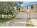 Charming townhome with a two-car garage and a driveway with mature trees and shrubs at 7977 S Kittredge St, Englewood, CO 80112