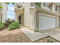 Exterior view of a townhome with a two-car garage, showing landscaping and the front door at 7977 S Kittredge St, Englewood, CO 80112