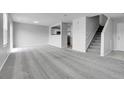 Open-concept living room featuring neutral carpeting, a staircase, and kitchen access at 7977 S Kittredge St, Englewood, CO 80112