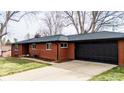 Front exterior of brick home with long driveway and an attached two-car garage at 3400 Moore St, Wheat Ridge, CO 80033