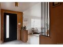 Inviting foyer with modern black door, accent paneling, and views into the stylishly decorated living room at 3400 Moore St, Wheat Ridge, CO 80033