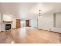 Unfurnished open-concept living room with hardwood floors, fireplace, and sliding glass doors at 23678 Pondview Pl # D, Golden, CO 80401