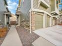 Side view of two-story home with three car garage and landscaped walkway at 1358 Carlyle Park Cir, Highlands Ranch, CO 80129