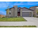 Modern home with gray exterior, red door, and two-car garage at 3839 Buchanan Way, Aurora, CO 80019