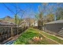 Large backyard featuring a fire pit, mature trees, and a wooden fence providing privacy at 2109 Jackson St, Golden, CO 80401