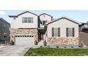 Two-story house with stone accents and a two-car garage at 6307 E 141St Ln, Thornton, CO 80602