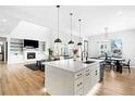 Modern kitchen island with white cabinets and stainless steel appliances at 6307 E 141St Ln, Thornton, CO 80602