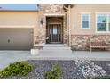 Close-up of the home's entrance, featuring a decorative stone accent wall and a cozy bench at 2134 S Poppy St, Lakewood, CO 80228