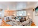 Cozy living room with hardwood floors, neutral walls, and ample natural light from large window at 5898 Parfet Ct, Arvada, CO 80004