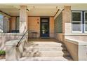Inviting front porch featuring brick columns, concrete stairs, and a glass block window accent at 1176 Gaylord St # 101, Denver, CO 80206