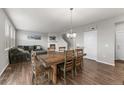 Open-concept space featuring a dining table, comfortable seating, fireplace and warm wood floors at 17311 Rose Mallow St, Parker, CO 80134