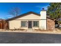 Charming single-story home with a stone chimney accent, complemented by manicured landscaping and neutral-toned siding at 3657 S Laredo St # E, Aurora, CO 80013