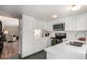 Clean kitchen boasts all white cabinets, stainless steel appliances and adjoins living room, for seamless entertaining at 3657 S Laredo St # E, Aurora, CO 80013
