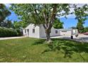 Spacious backyard with lush green grass, a mature tree, and a detached garage at 5525 Pierce Ct, Arvada, CO 80002