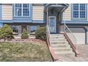 Inviting home entry with a covered porch and charming landscaping, including a brick retaining wall at 11437 W 103Rd Ave, Broomfield, CO 80021