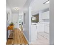 Hallway leading to the kitchen with wood-look flooring, showcasing the home's open layout at 1885 S Quebec Way # J106, Denver, CO 80231