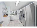 Modern kitchen featuring stainless steel appliances, white cabinetry, and a view to an adjacent space at 1885 S Quebec Way # J106, Denver, CO 80231