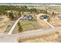 Stunning aerial view showing the property with two homes, long driveways and lush greenery at 1567 Arrowpoint Ct, Franktown, CO 80116