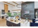 Open-concept living area with modern finishes, including wood beams, a fireplace and luxury vinyl plank flooring at 1567 Arrowpoint Ct, Franktown, CO 80116