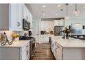 Well-lit kitchen featuring white cabinetry, stainless steel appliances, and a breakfast bar at 1784 Cade Ave, Castle Rock, CO 80104