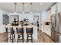 Bright, modern kitchen features white cabinetry, quartz countertops, stainless appliances, and pendant lighting at 1784 Cade Ave, Castle Rock, CO 80104