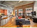 Spacious living area with exposed brick, wood floors, and kitchen at 1801 Wynkoop St # 205, Denver, CO 80202