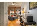 Open living room with exposed brick, wood floors, and workspace at 1801 Wynkoop St # 205, Denver, CO 80202