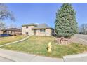 Charming two-story home with a manicured lawn, mature trees, brick landscaping, and a vintage fire hydrant at 2488 S Zurich Ct, Denver, CO 80219