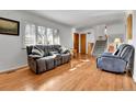 Bright living room with hardwood floors, a comfortable gray sofa, and large windows with lots of natural light at 2488 S Zurich Ct, Denver, CO 80219