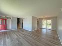 Open-concept living room showing hardwood floors, neutral paint, staircase, and sliding doors to backyard at 1822 Ura Ln, Northglenn, CO 80234